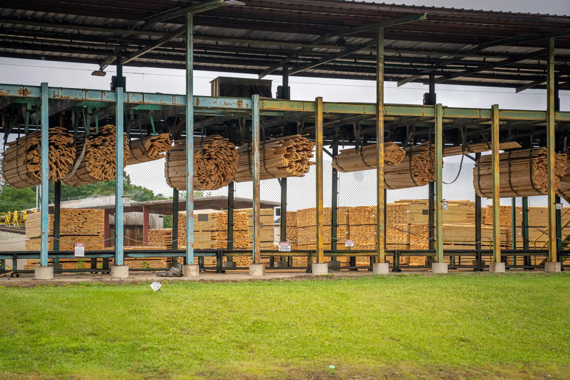 Open sided drying shed with timber packs stacked under a long roof