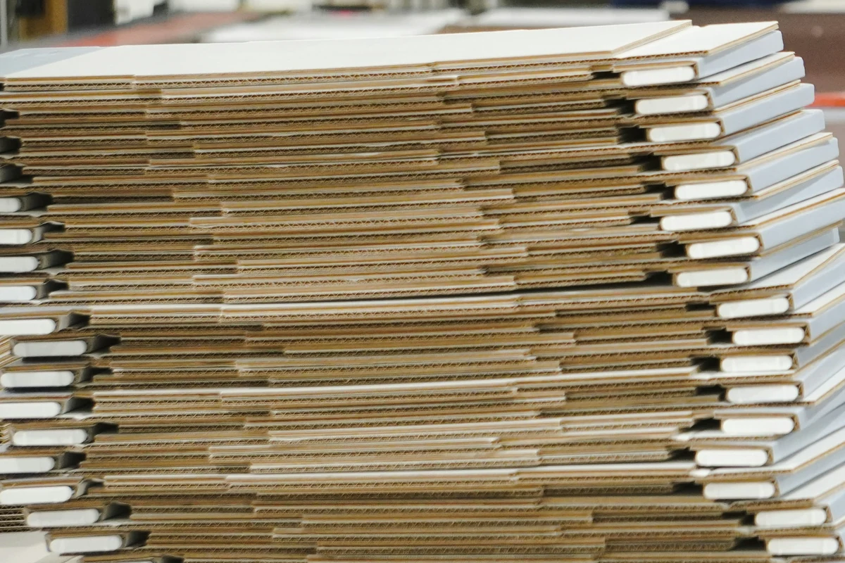 Stacks of folded carton blanks on a converting line, waiting to be worked